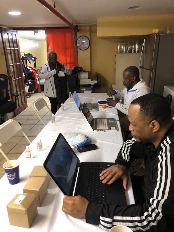 A man is sitting at a table using a laptop computer