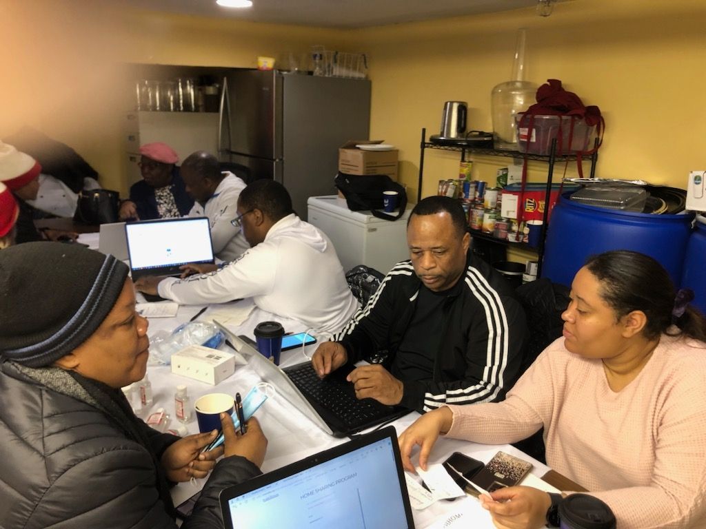 A group of people are sitting at a table with laptops.