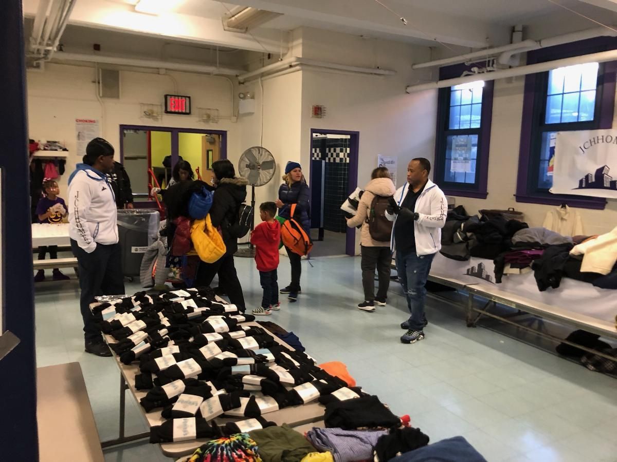 A group of people are standing around a table in a room.