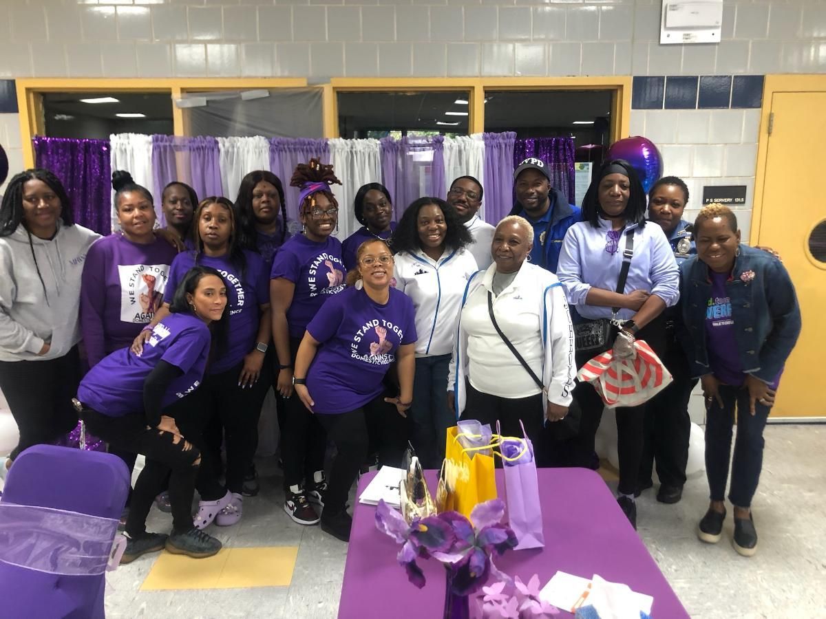 A group of women in purple shirts are posing for a picture.