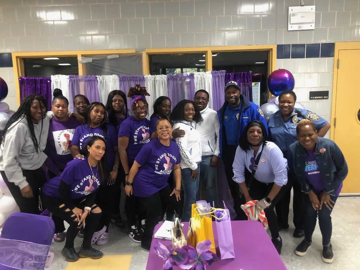 A group of people in purple shirts are posing for a picture.