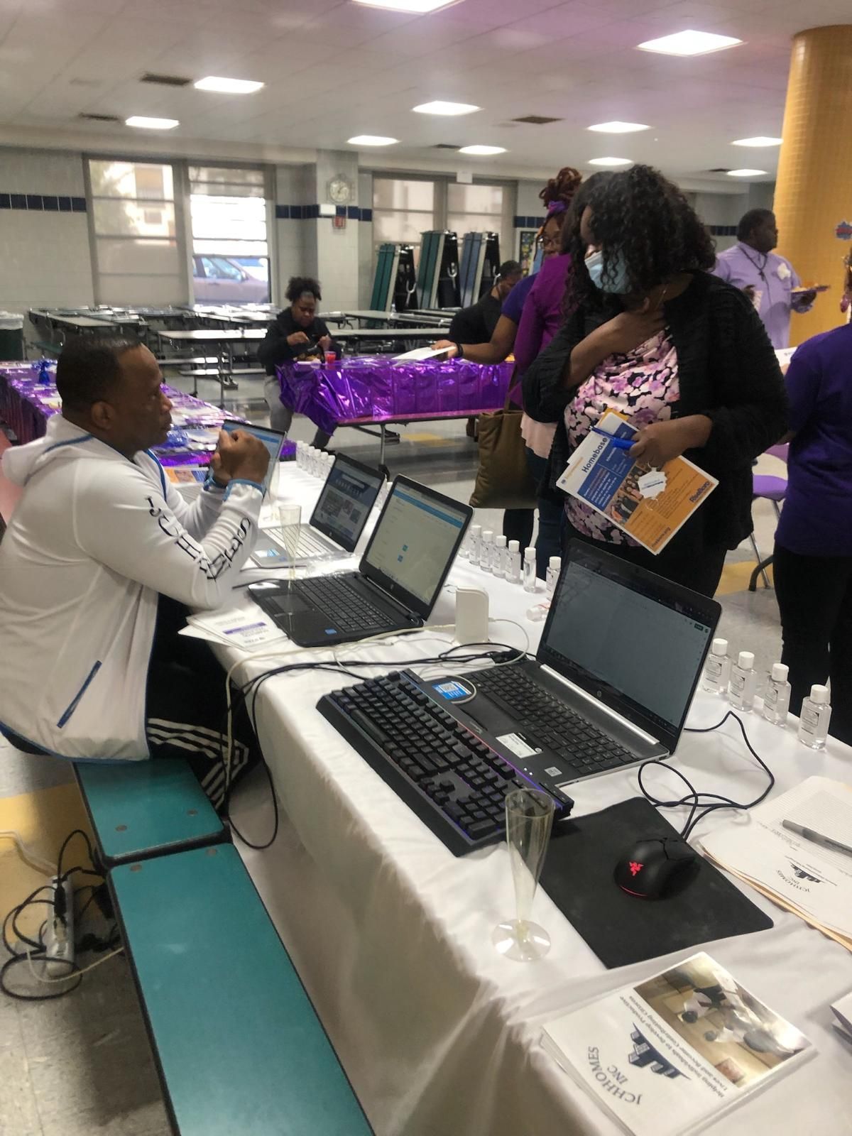 A group of people are sitting at a table with laptops.
