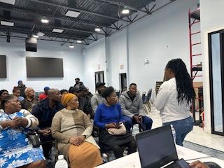 A woman is giving a presentation to a group of people in a room.
