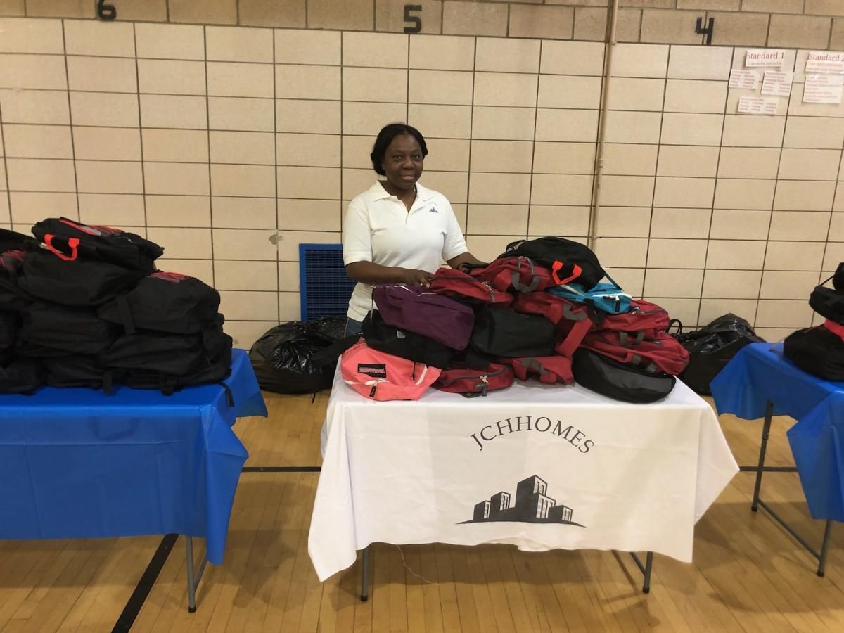 A woman stands behind a table with a sign that says ichhomes