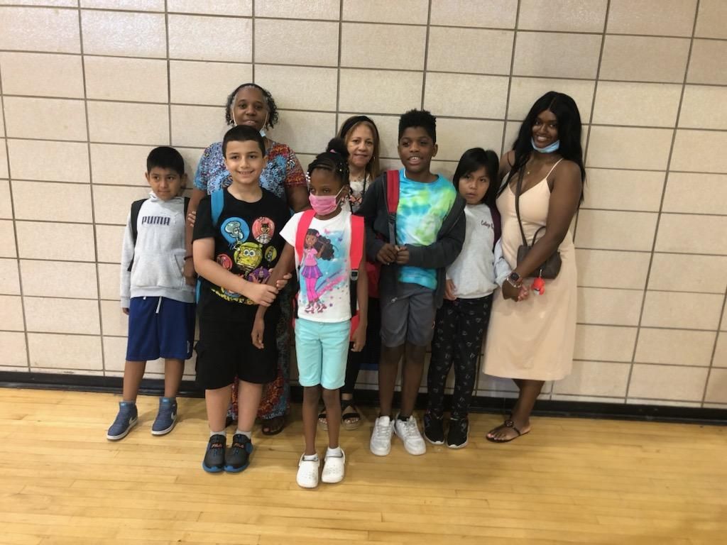 A group of children and adults are posing for a picture.