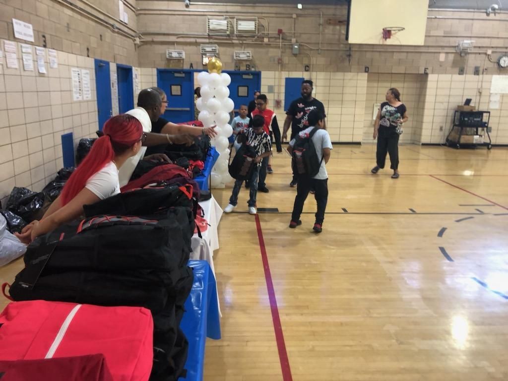 A group of people are standing in a gym.