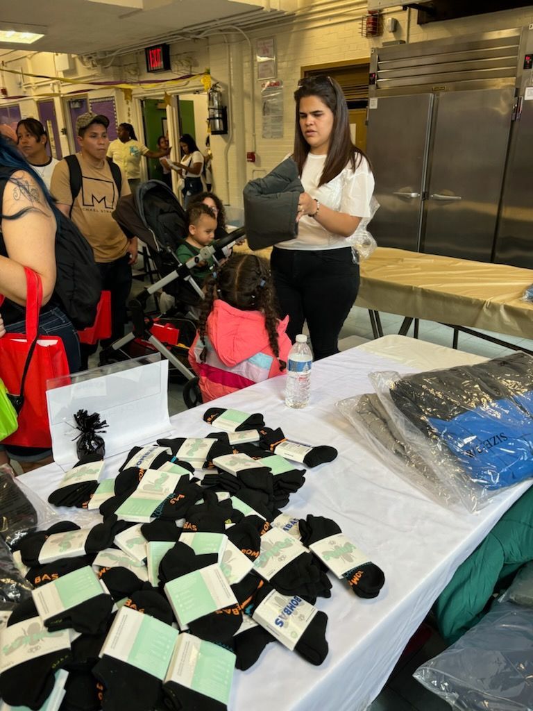 A woman is standing next to a table with socks on it.