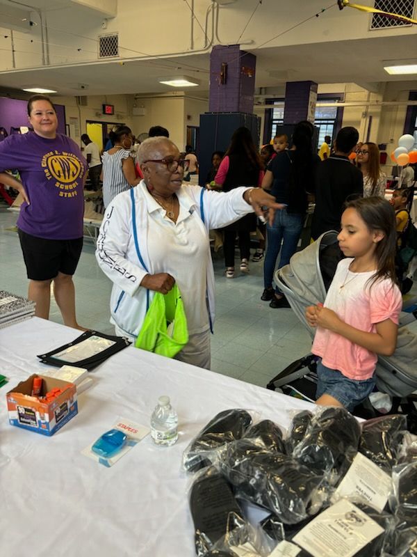 A woman is standing next to a little girl at a table.