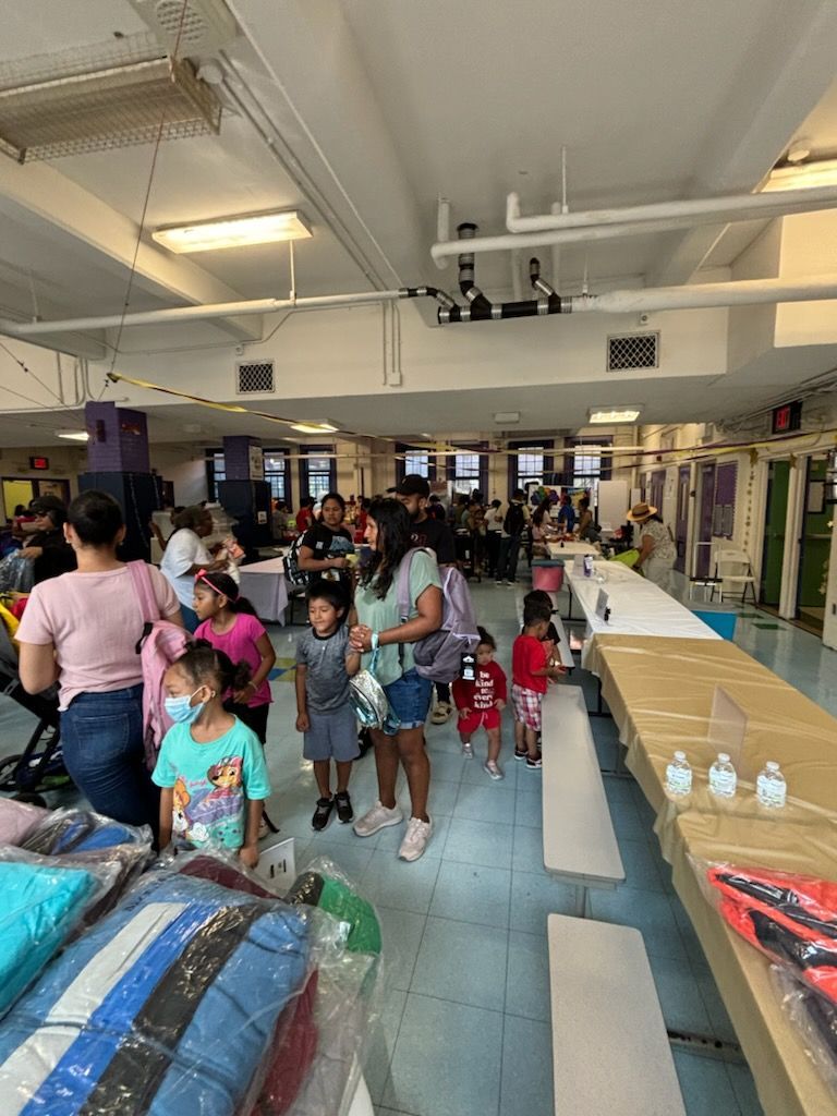 A group of people are standing in a large room.