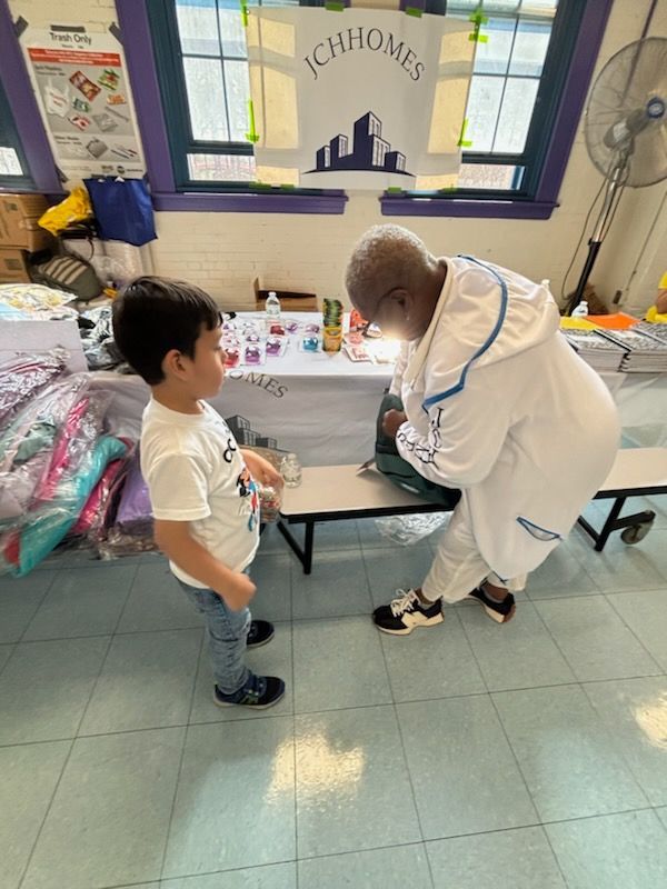 A man in a white robe is talking to a young boy in a room.