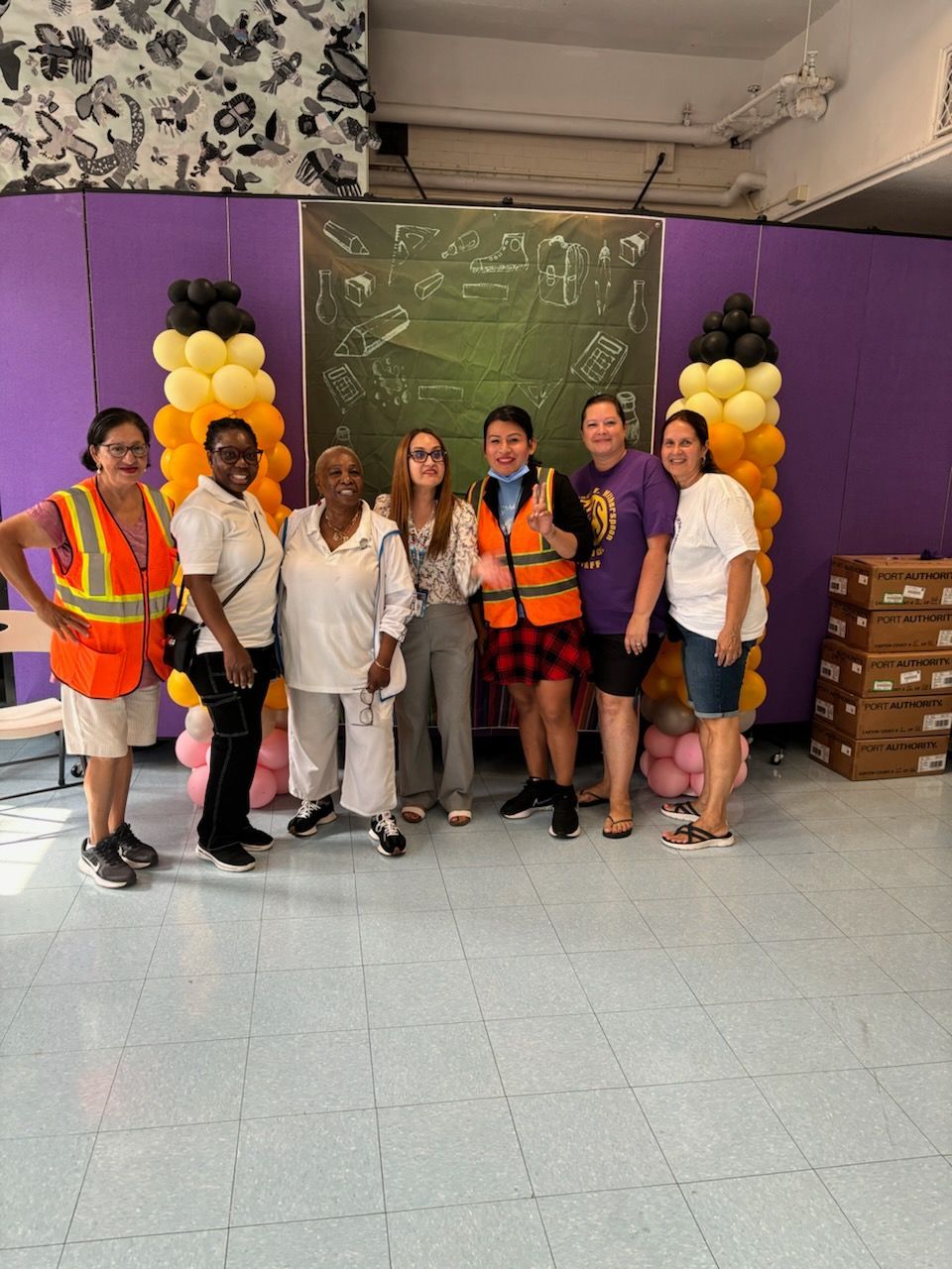 A group of women are posing for a picture in a room with balloons.