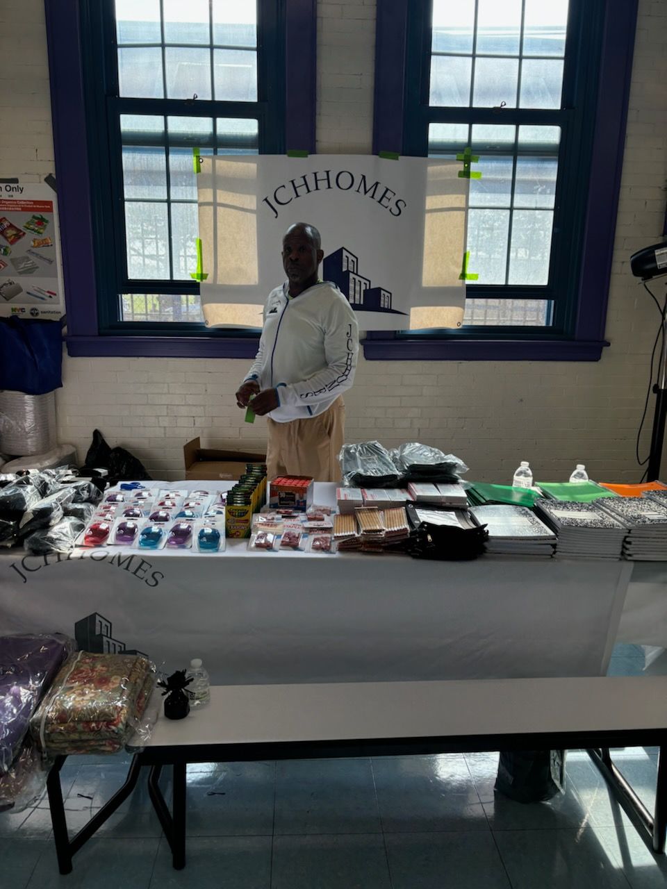 A man stands behind a table with a sign that says ichhomes