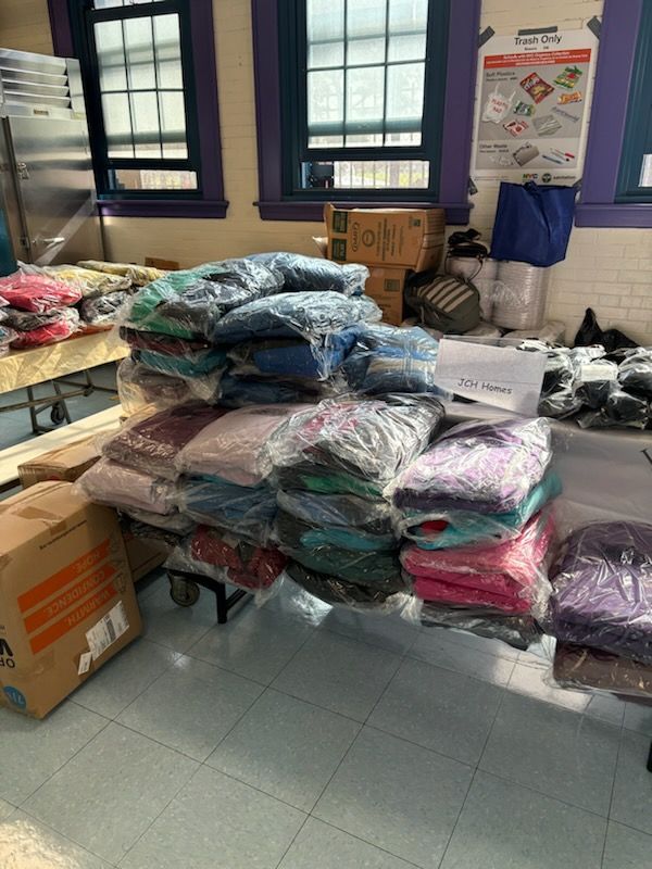 A bunch of clothes are stacked on top of each other in a room.