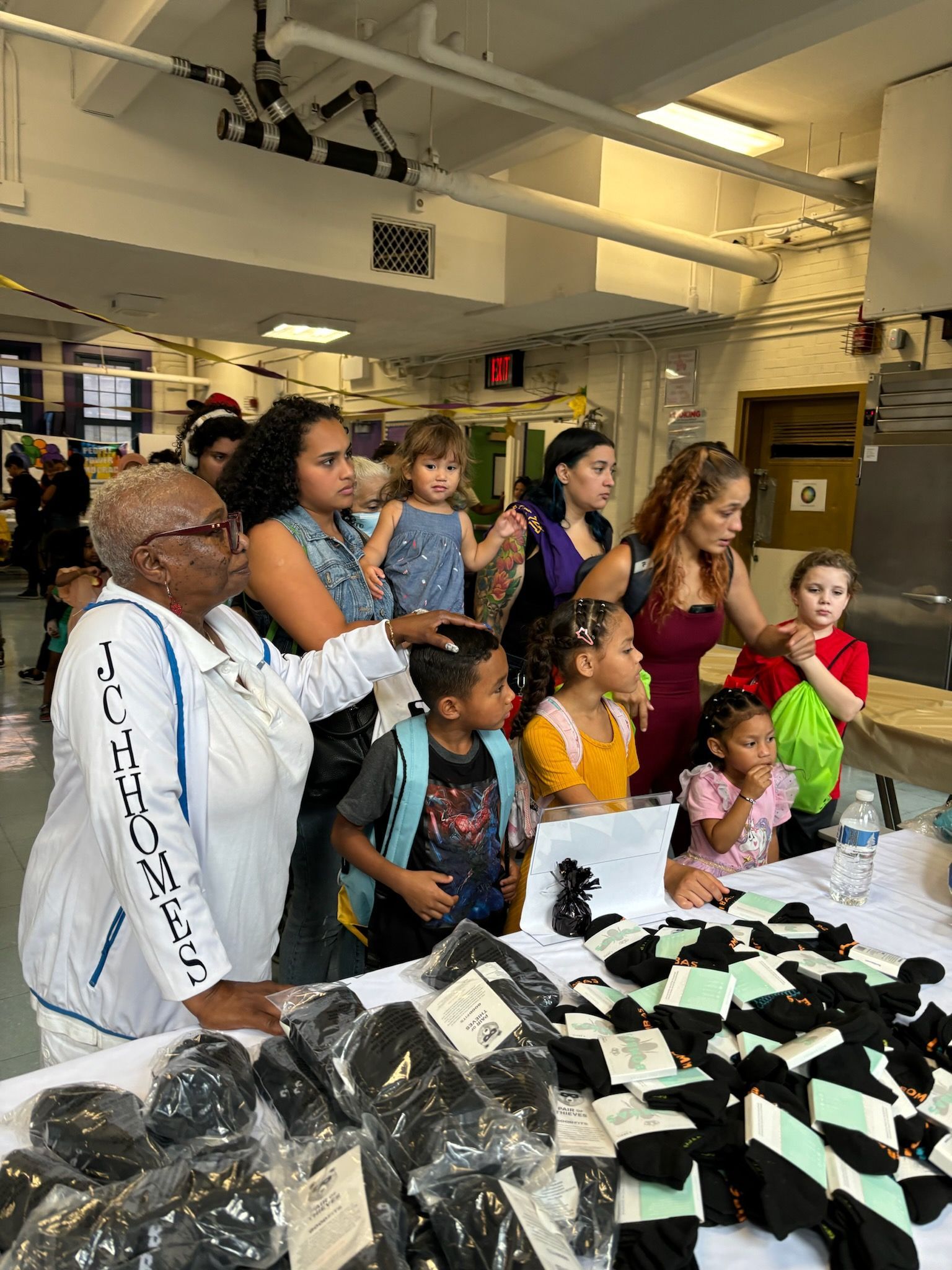 A group of people are standing around a table with socks on it.