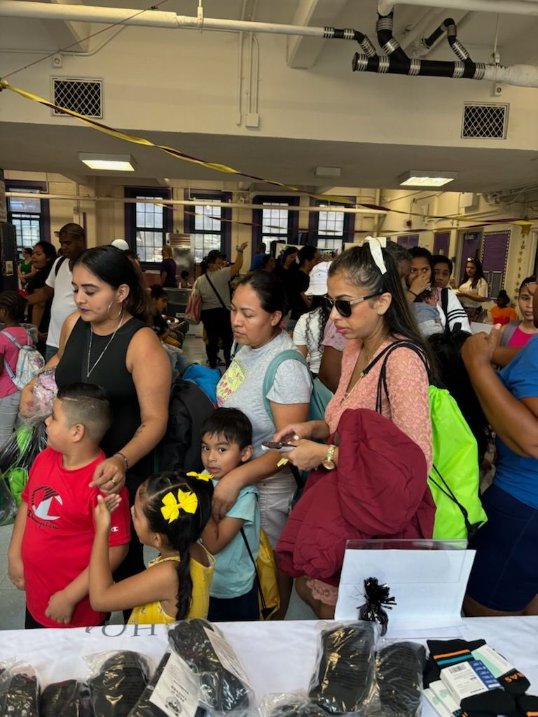 A group of people are standing around a table in a room.