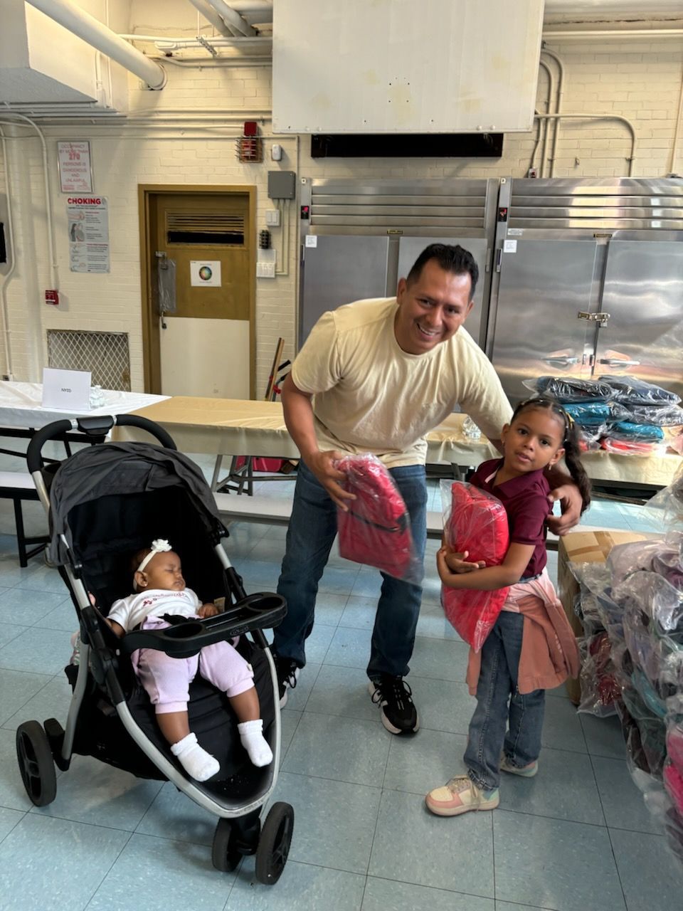 A man is standing next to a stroller with a baby in it.