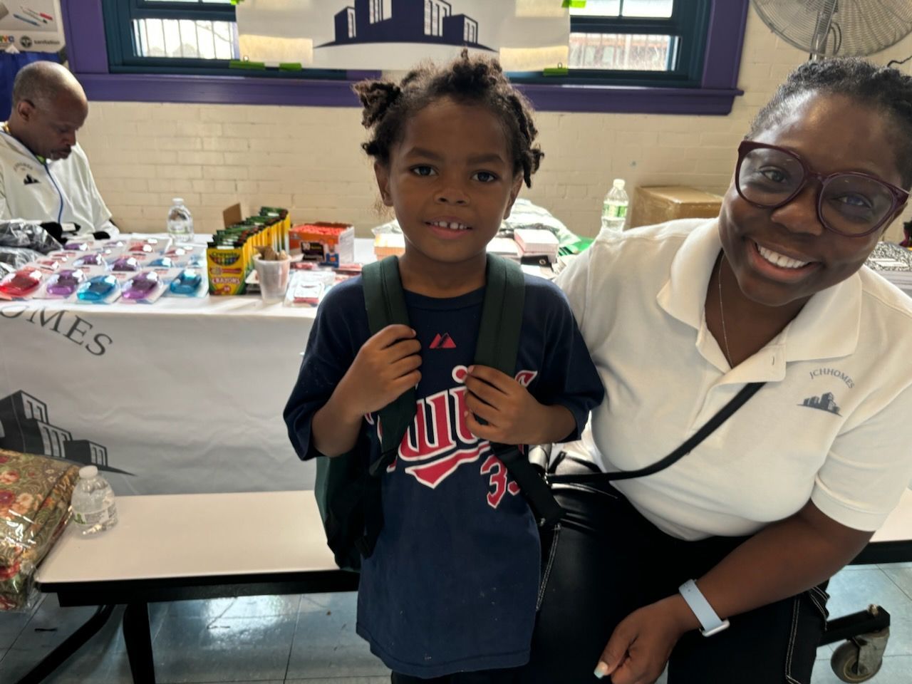 A woman is sitting next to a young boy wearing a backpack