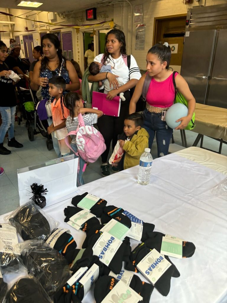 A group of people are standing around a table with socks on it.