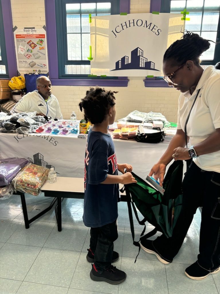A woman is helping a young boy pack his backpack.