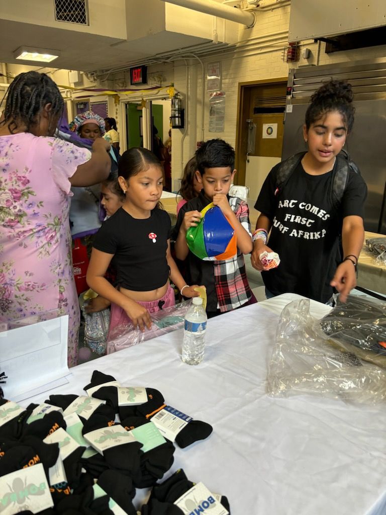 A group of children are standing around a table holding balloons.