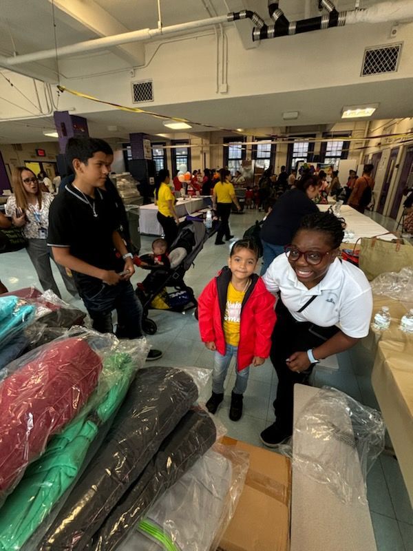 A woman and a little girl are standing next to each other in a room.