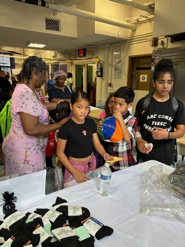 A group of children are standing around a table in a room.