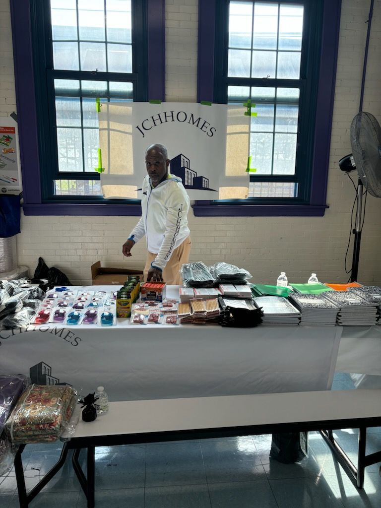 A man is standing at a table in front of a window.