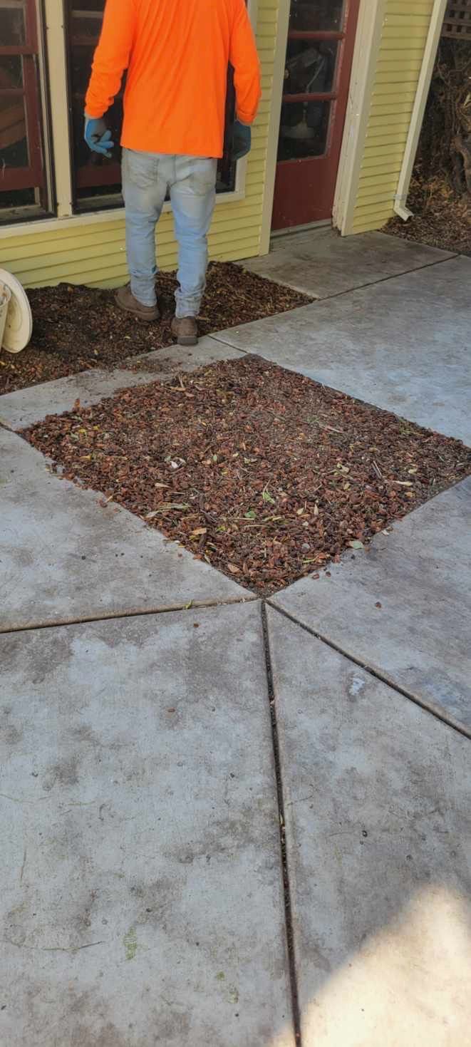 Person in orange shirt on patio with decorative gravel in diamond pattern.