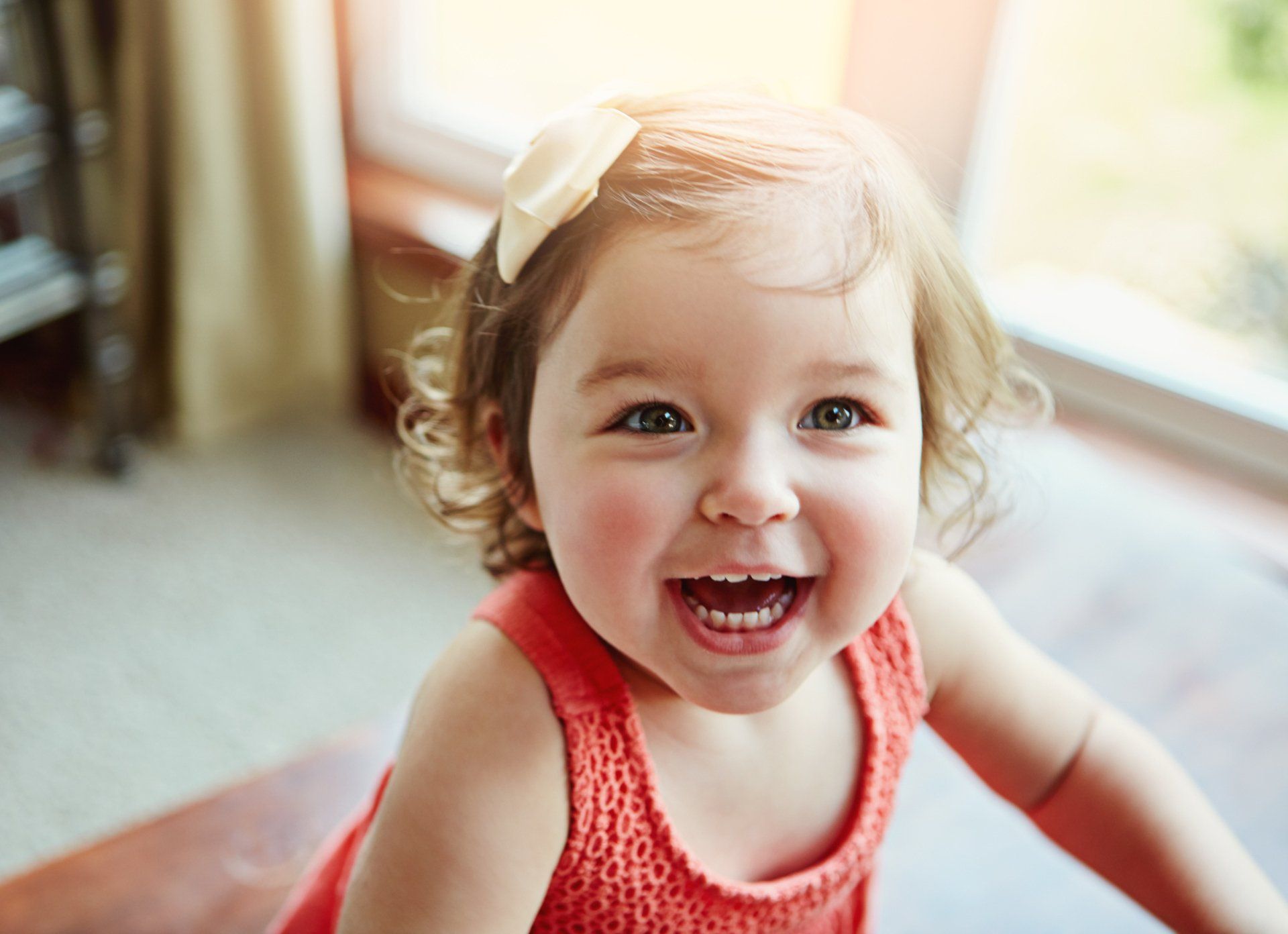 A happy toddler is smiling in the sun