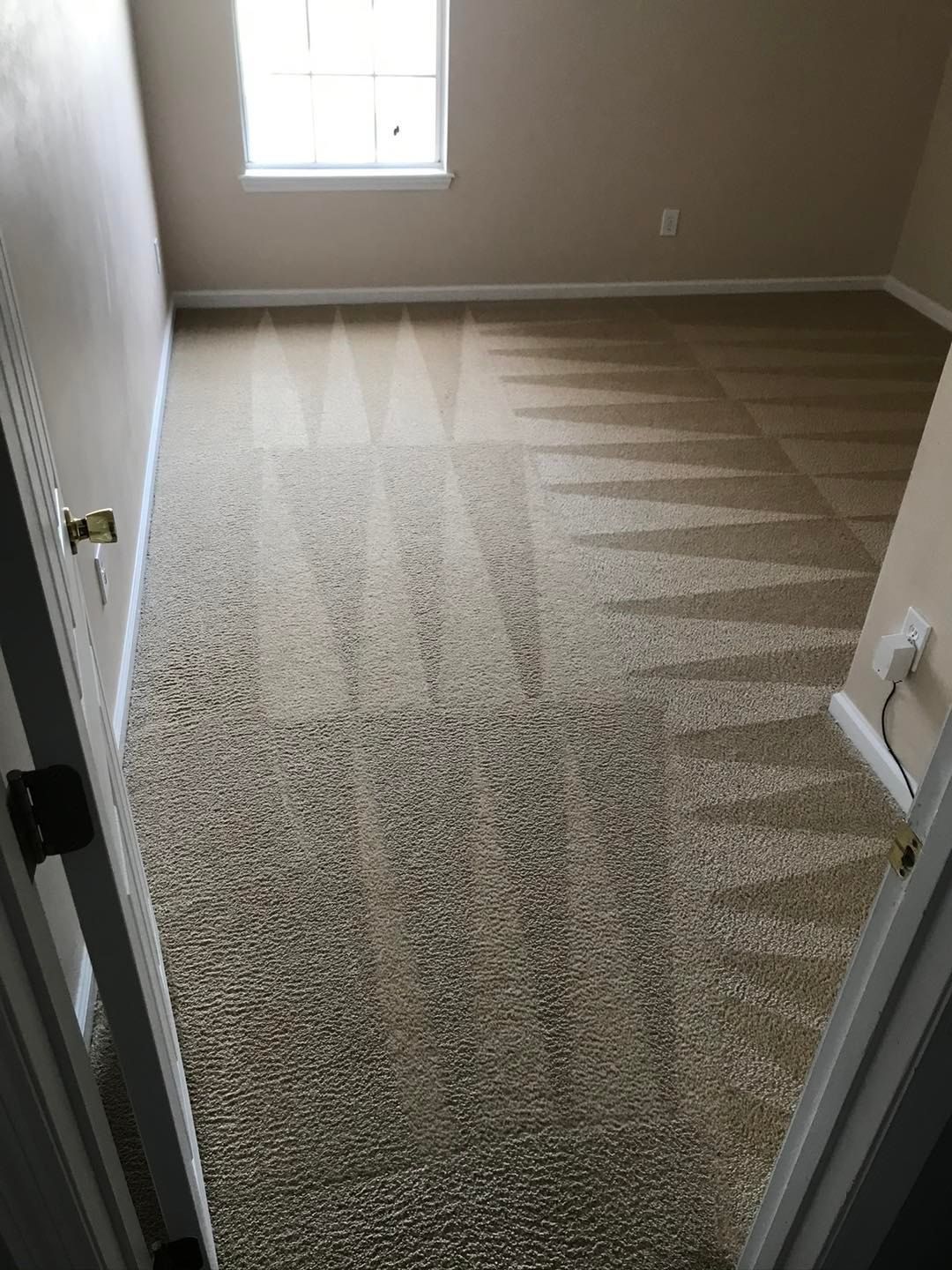 a bedroom with a carpeted floor and a window .