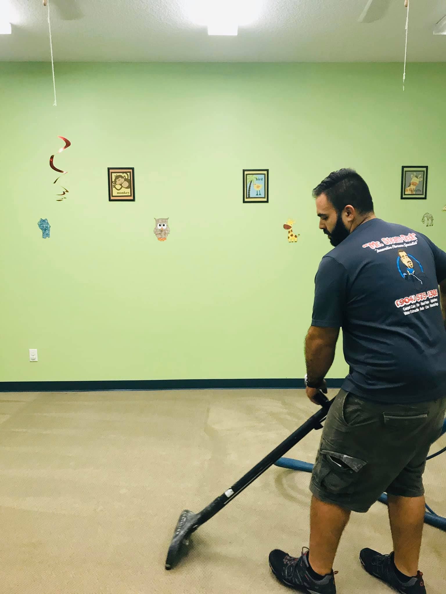 a man is using a vacuum cleaner to clean a carpet in a room .