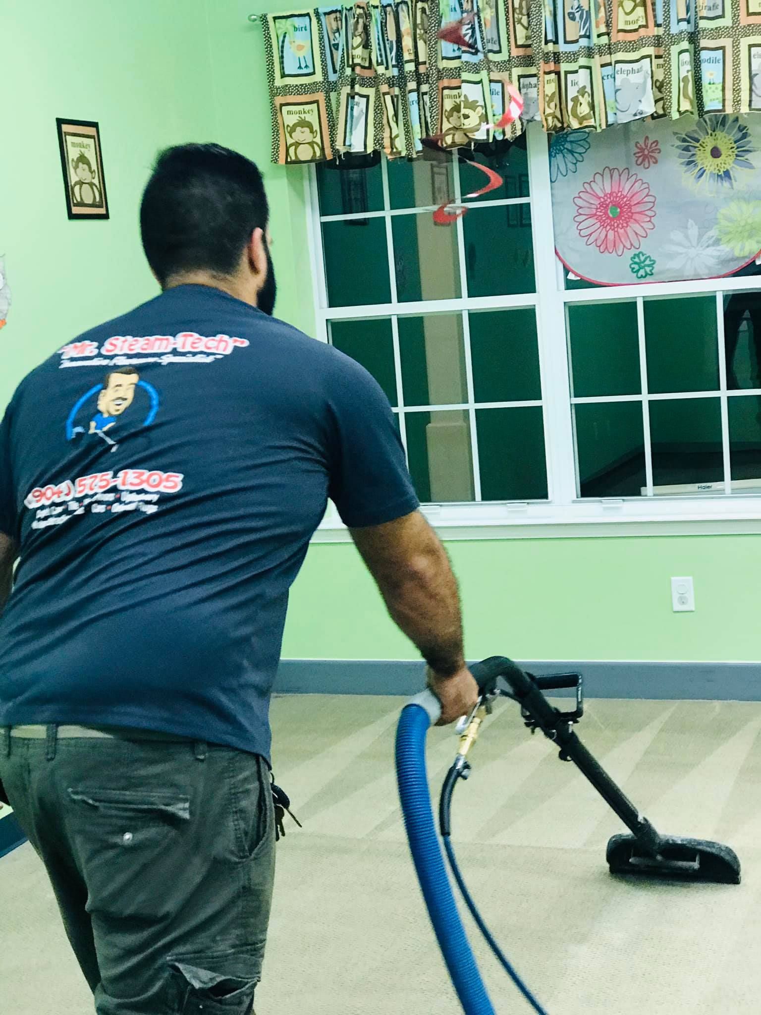 a man is cleaning a carpet with a vacuum cleaner .