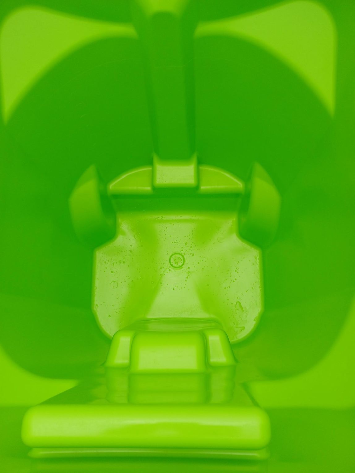 A man is putting trash into a trash can on the sidewalk.