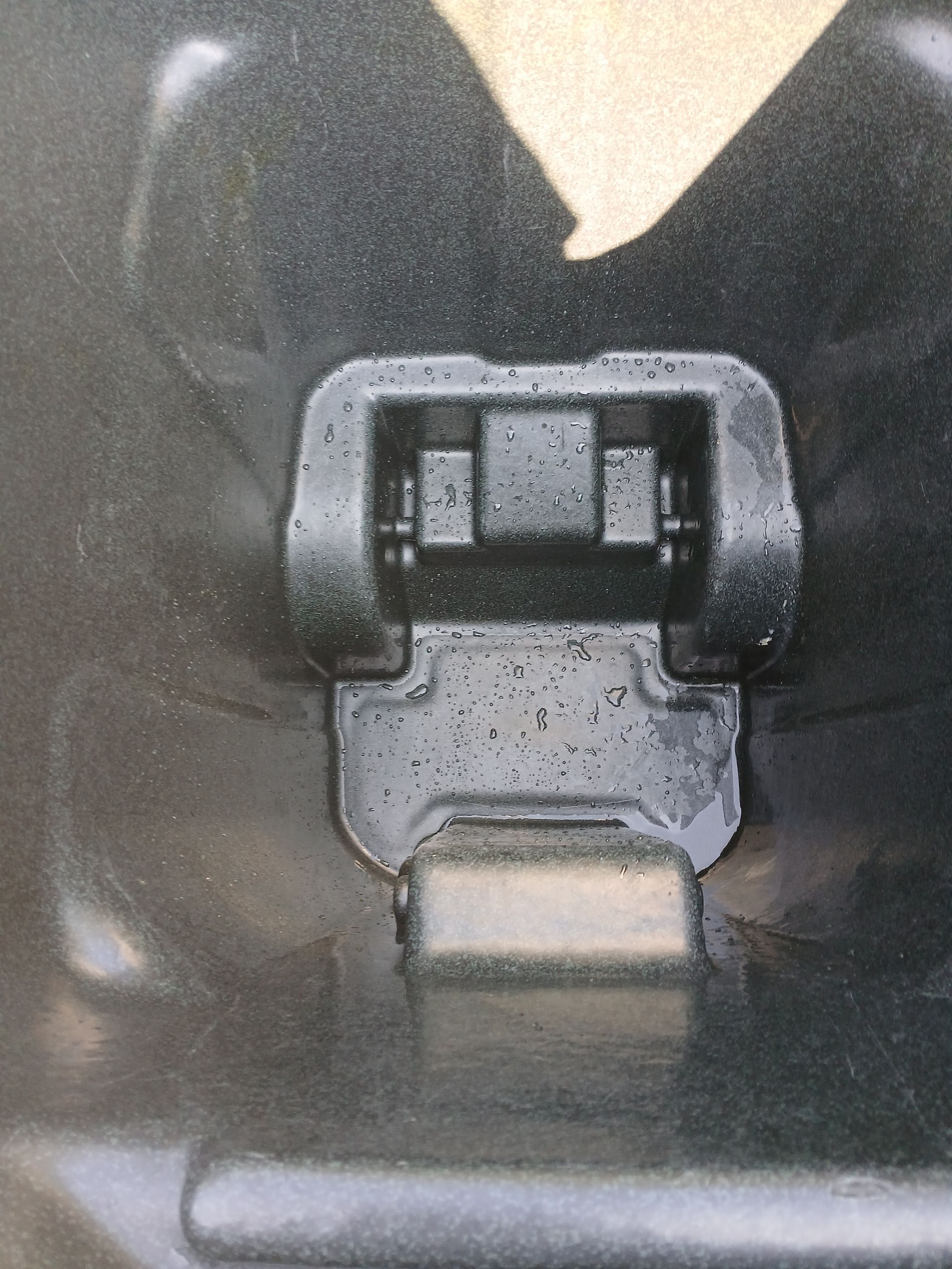 A man is putting trash into a trash can on the sidewalk.