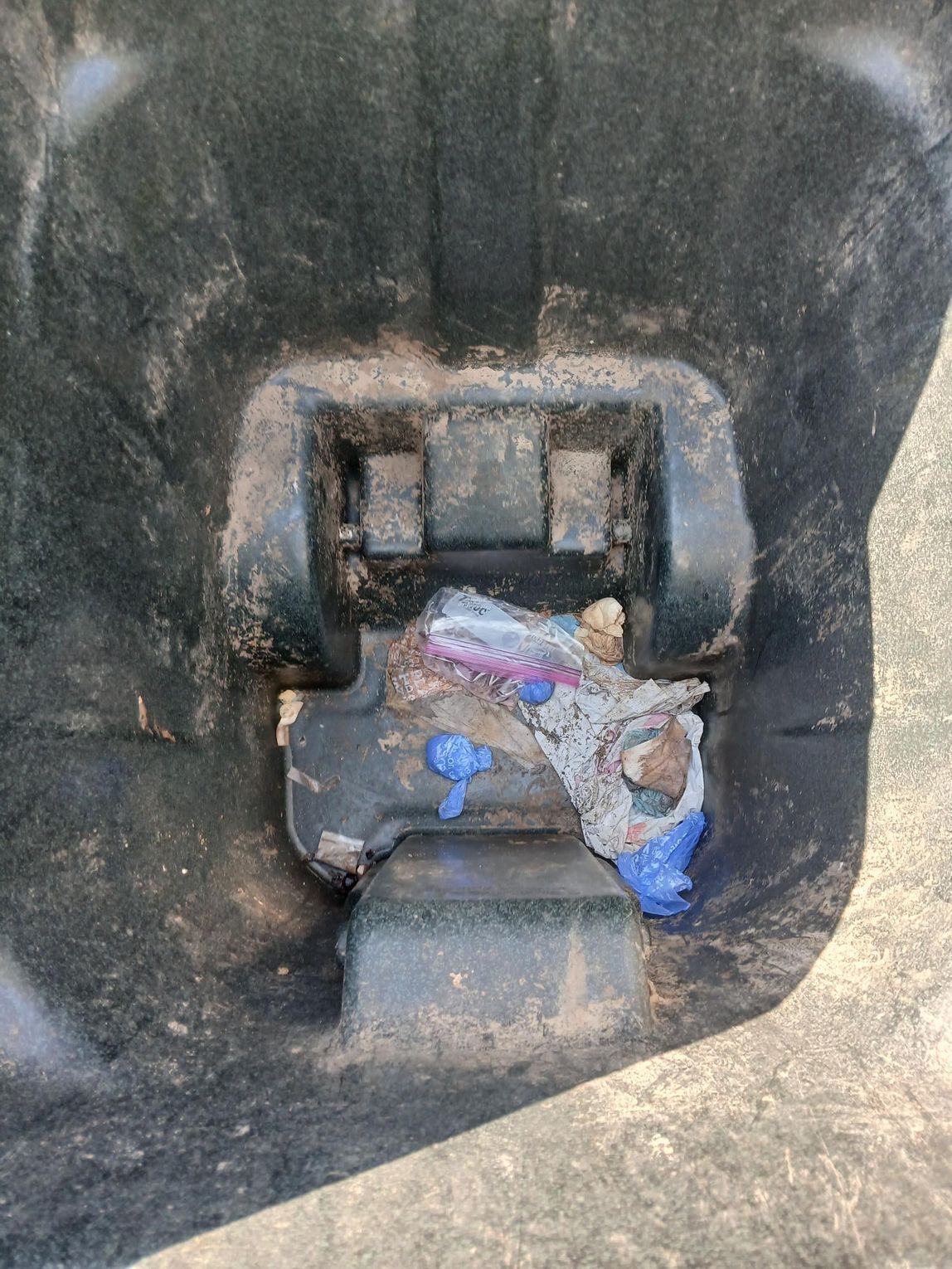 A man is sitting in a chair looking at his cell phone.