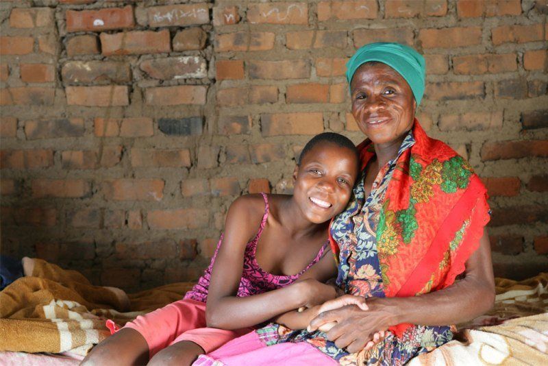 World AIDS Day: Two African women sitting in front of a brick wall