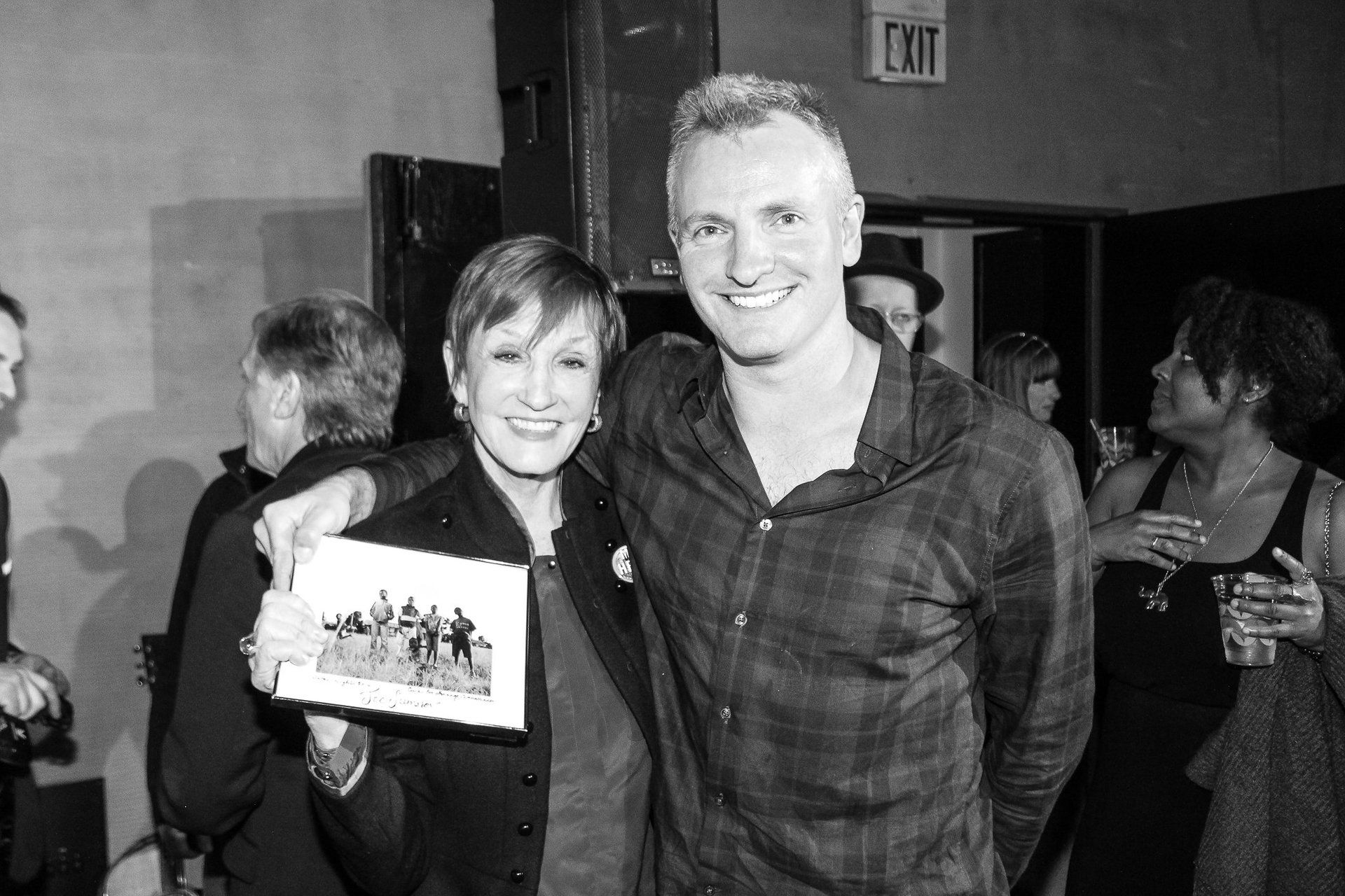 A man and a woman are posing for a picture in a black and white photo.
