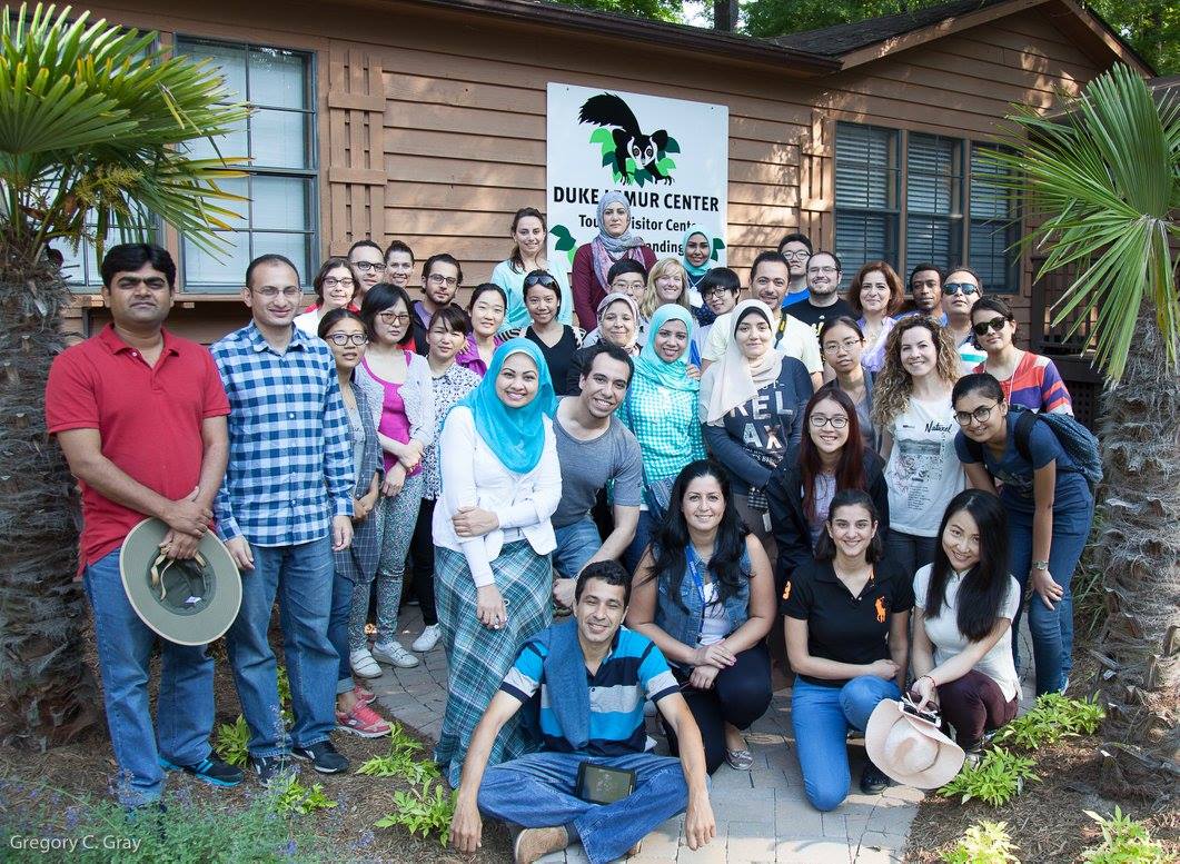 A large group of people standing and posing in from of the Duke global Health institute center