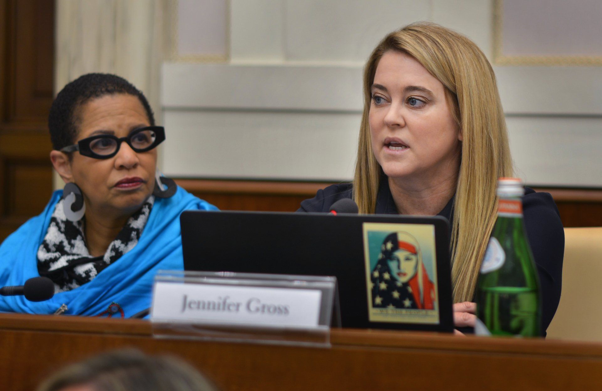Two women are sitting at a table with a name tag that says jennifer gross
