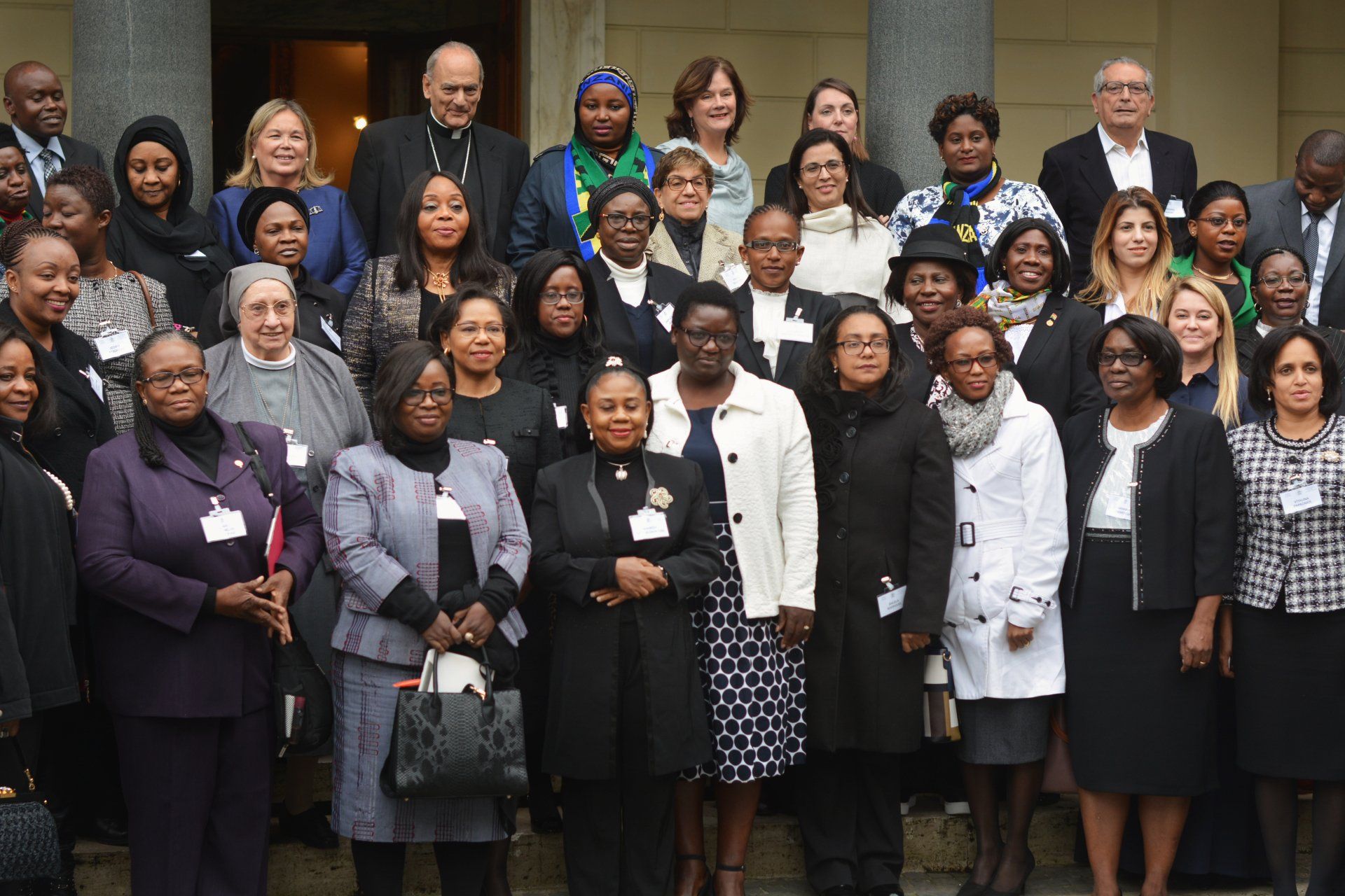A group of people are posing for a picture on the steps of a building.