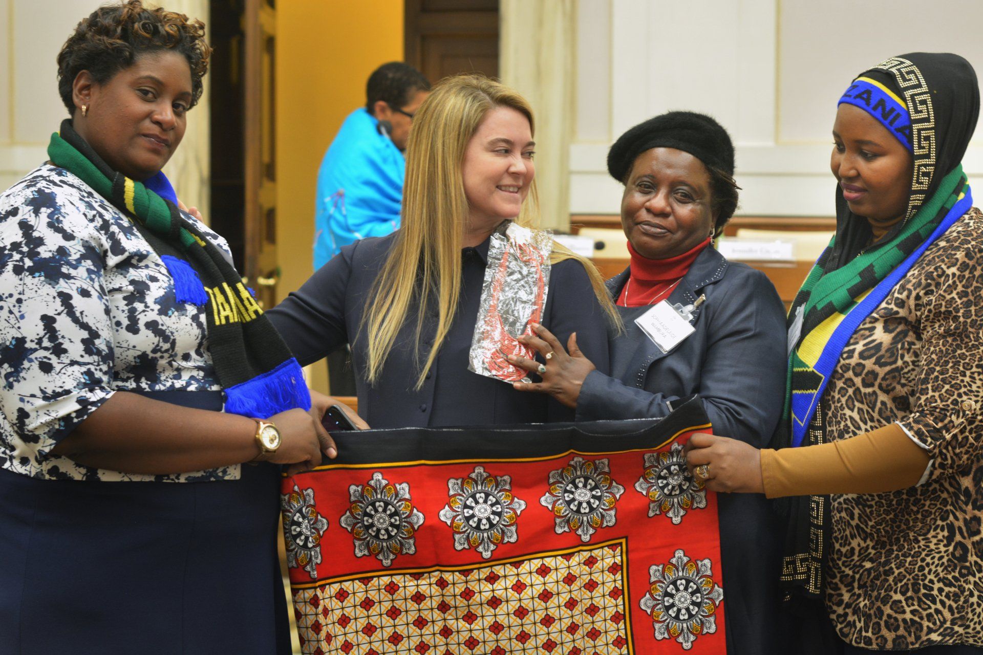 A group of women are standing next to each other holding a piece of fabric