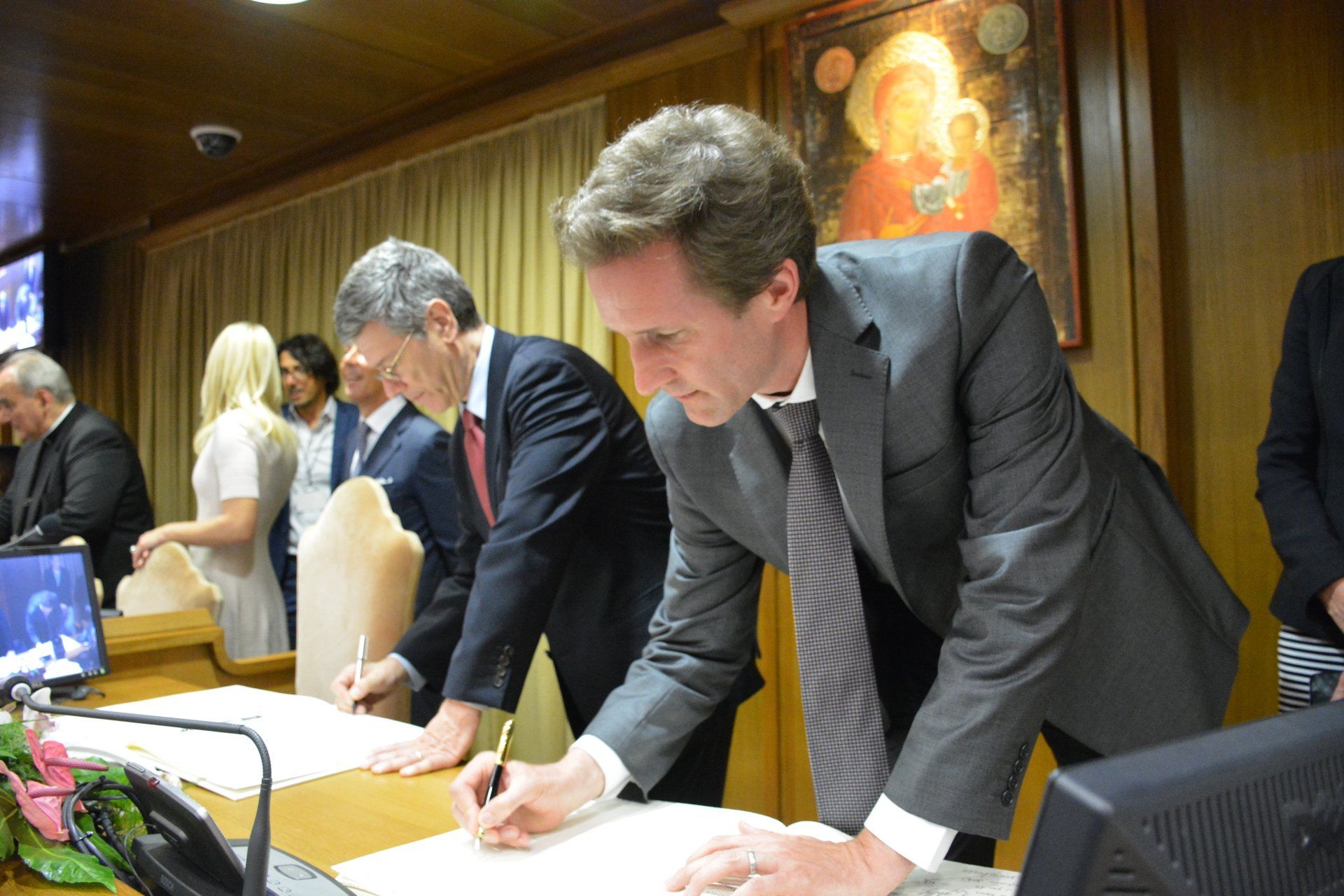 Men signing documents to address Modern Slavery and Climate Change Meeting