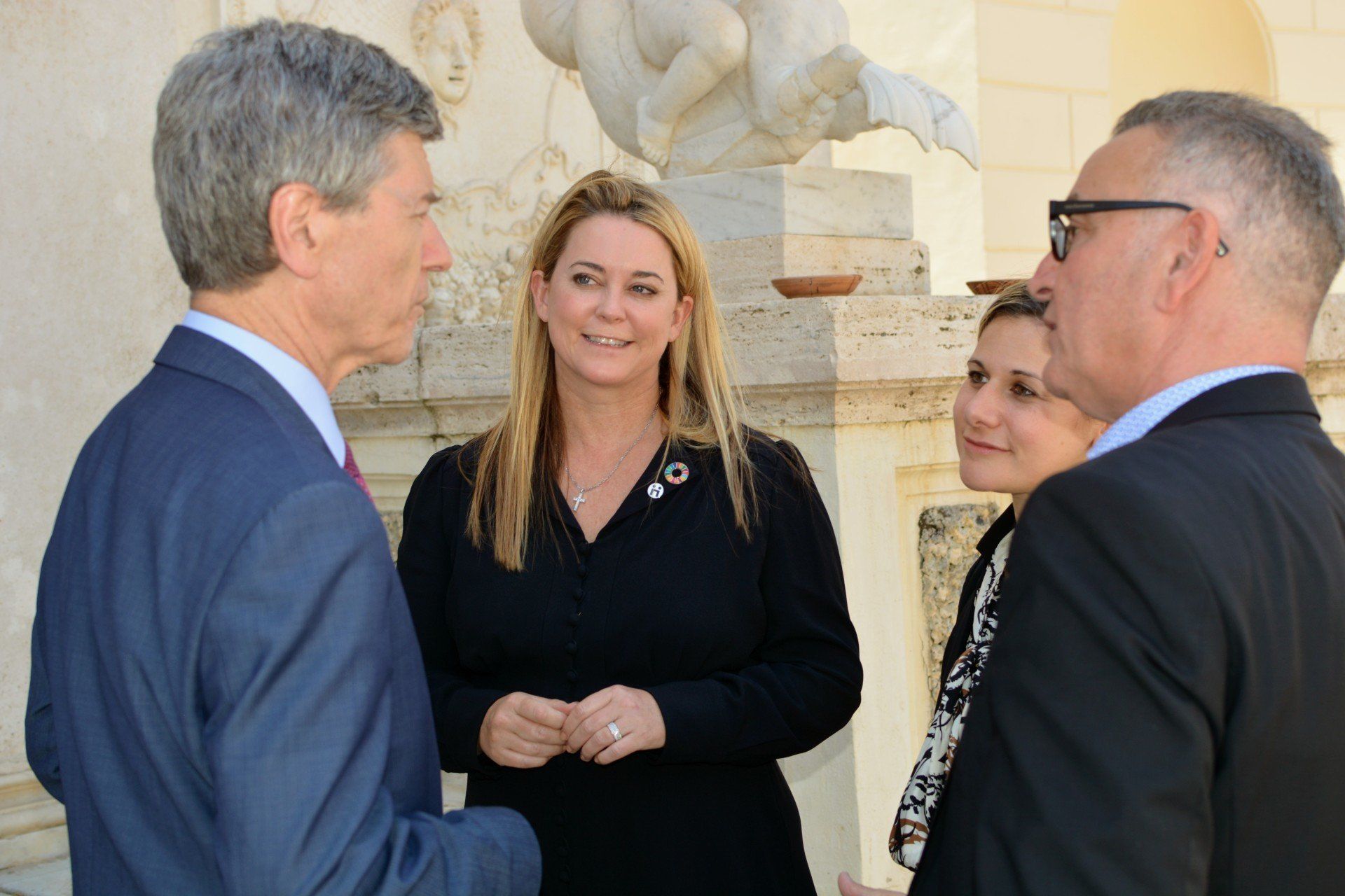 Jennifer Gross talking with a small group of people at the Ethics in  Action and Indigenous Peoples meeting