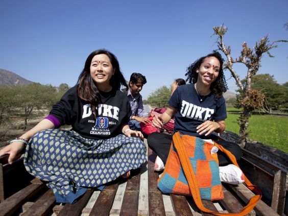 Two girls wearing Duke global health health institute shirts in the bed of a pickup truck