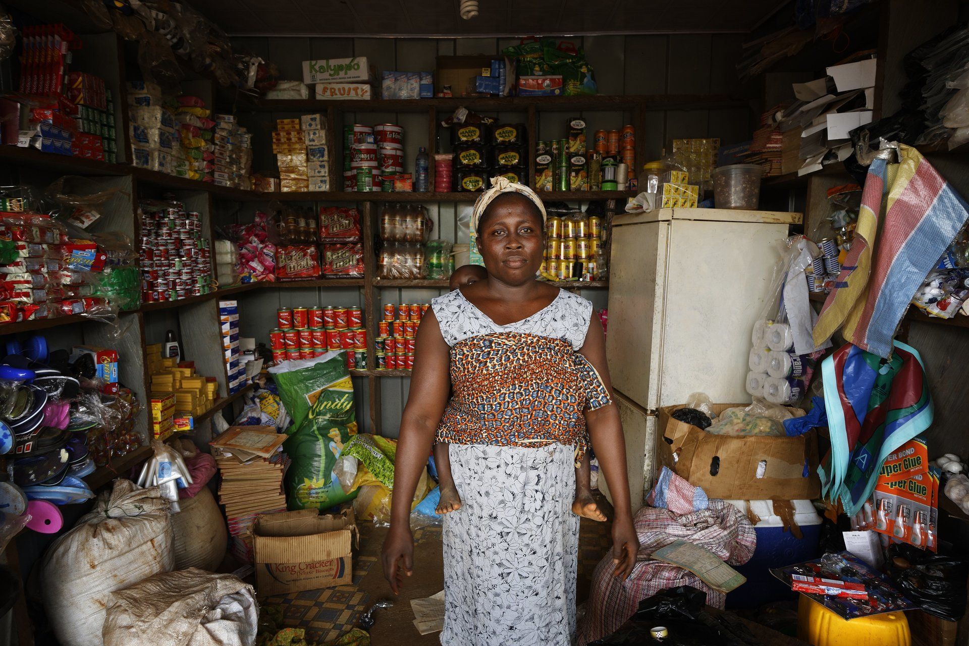 MVP: A women with a baby on here back, standing in a shop