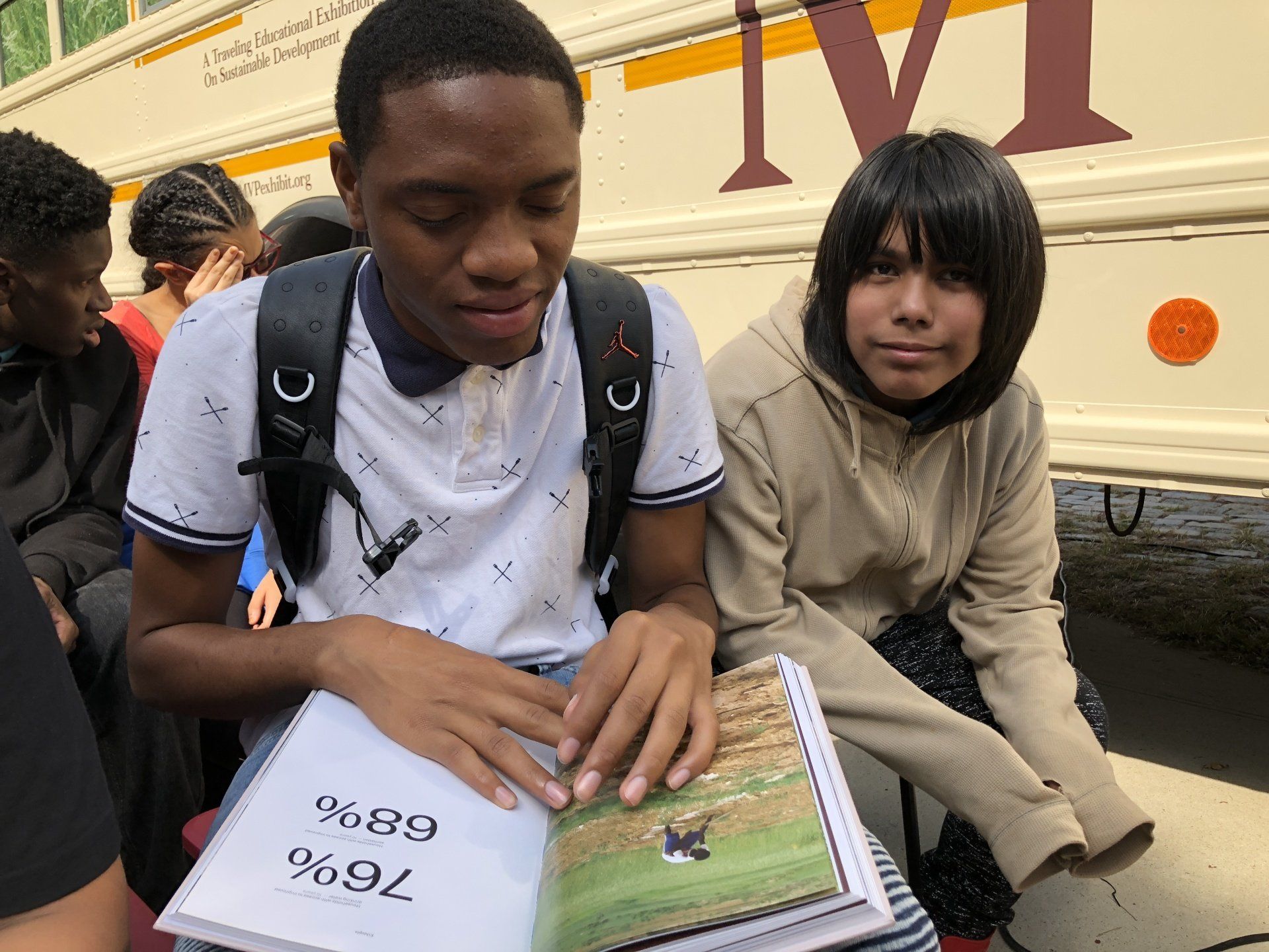 Millennium Villages Project get on the bus campaign where two children are ready a book