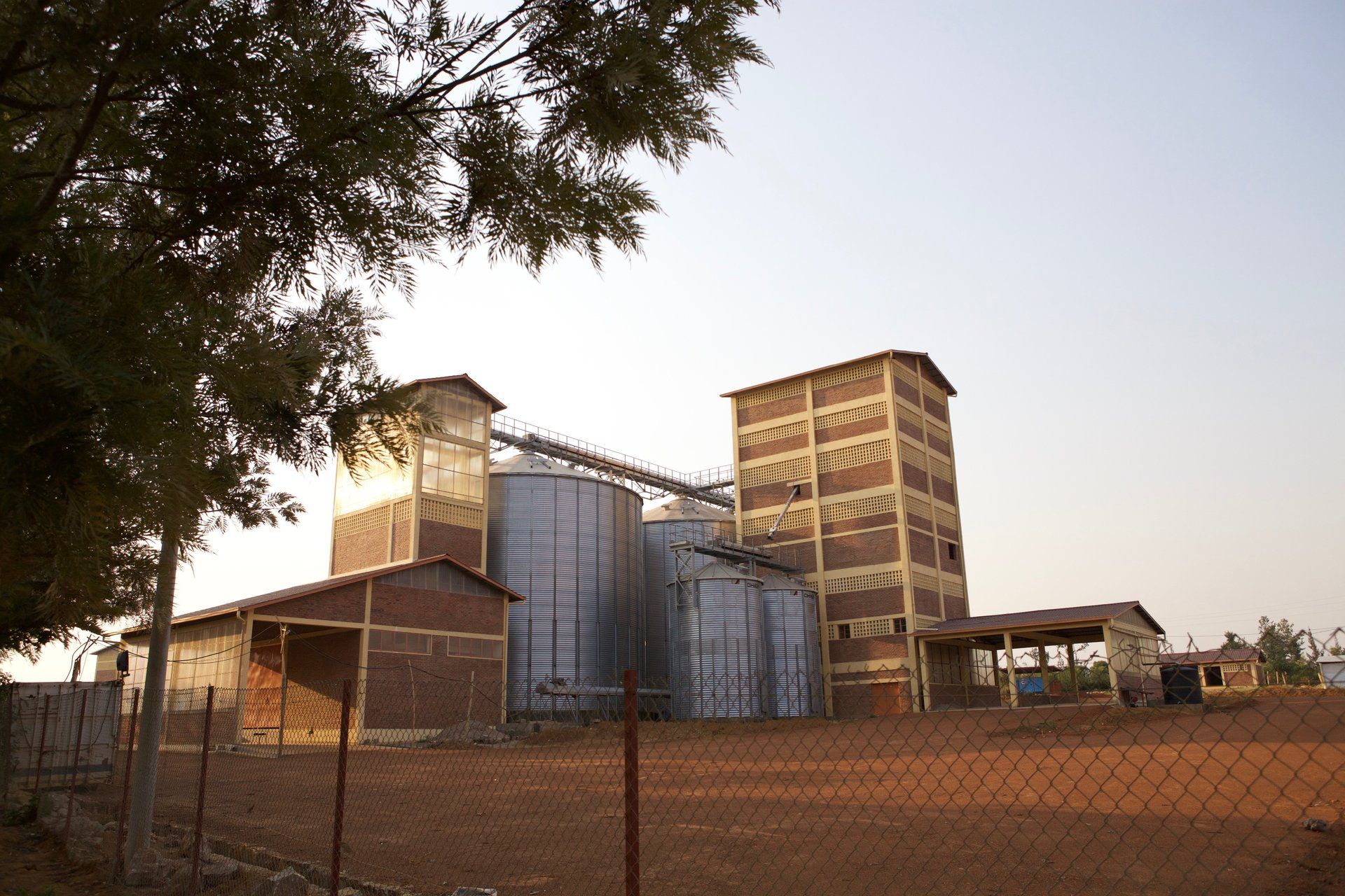 Industrial facility with silos and conveyor belts, possibly part of agricultural development in Rwanda.