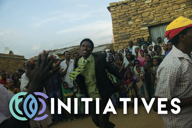 A group of people dancing in front of a sign that reads 