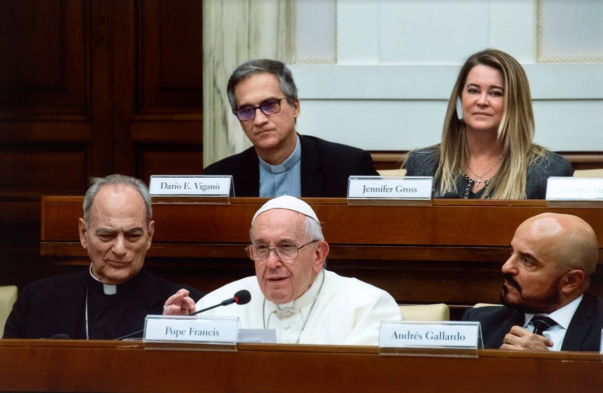 The pope sitting at a Vatican Summit conference speaking into a mic