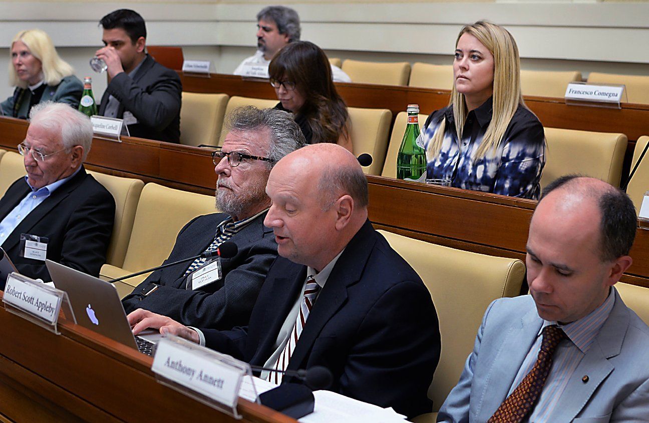 A man talking into a mic during a faith and science  conference